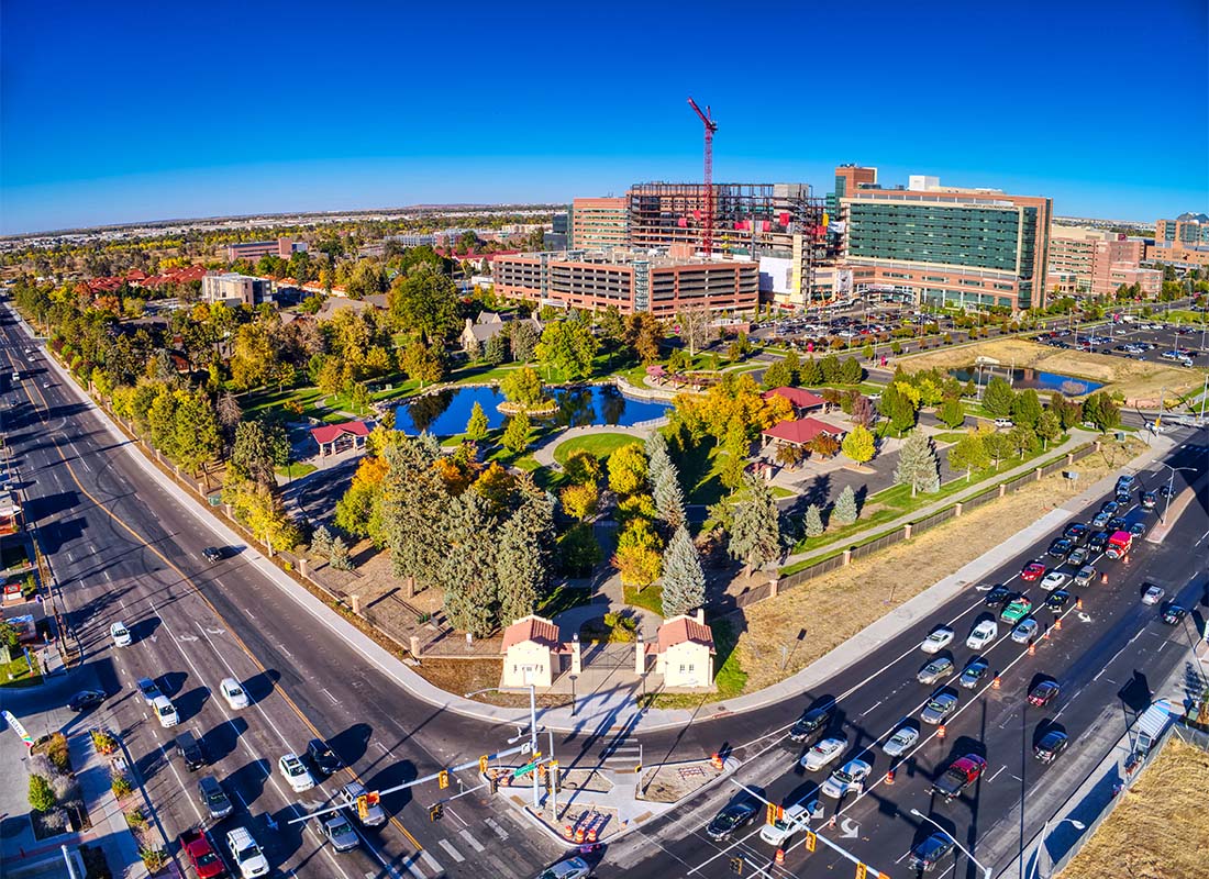 Aurora, CO - Aerial View of a Busy Intersection with Homes and Commercial Buildings on a Sunny Day in Aurora Colorado